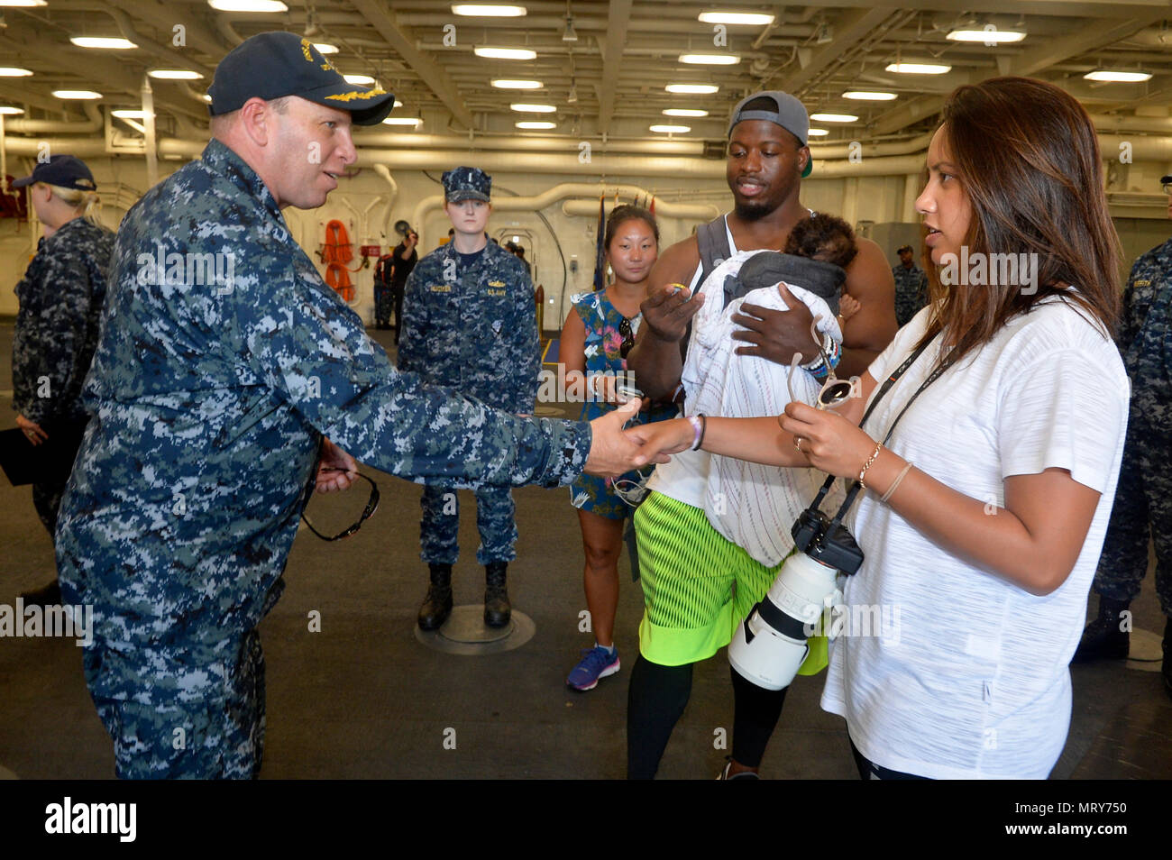 170711-N-IE405-388 SAN DIEGO (11 juillet 2017), USS John P. Murtha (LPD 26) Commandant Le capitaine Kevin Parker montre son appréciation et les mains des pièces pour l'exécution de Carolina Panthers retour Jonathan Stewart et sa famille pour visiter le navire. Stewart était en tournée le navire après avoir accueilli un camp de football des jeunes pour plus de 200 enfants de militaires de la base navale de San Diego. (U.S. Photo par marine Spécialiste de la communication de masse 2e classe Indra Bosko/libérés) Banque D'Images