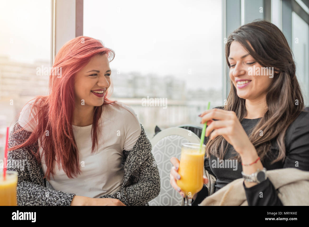 Portrait de deux jeunes belles filles. Deux jeunes femmes bénéficiant d'amis ensemble dans un restaurant de rire, parler et le commérage. Banque D'Images