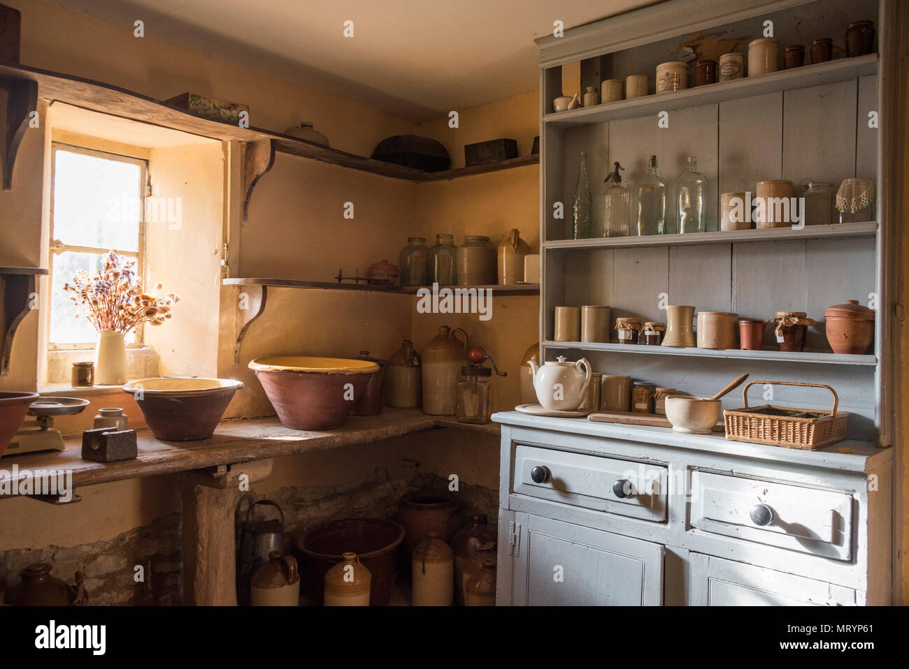 Ustensiles de cuisine anciens sur des étagères et la commode dans l'arrière-cuisine, le Manoir, Cogges Farm Museum, Witney, Oxfordshire Banque D'Images