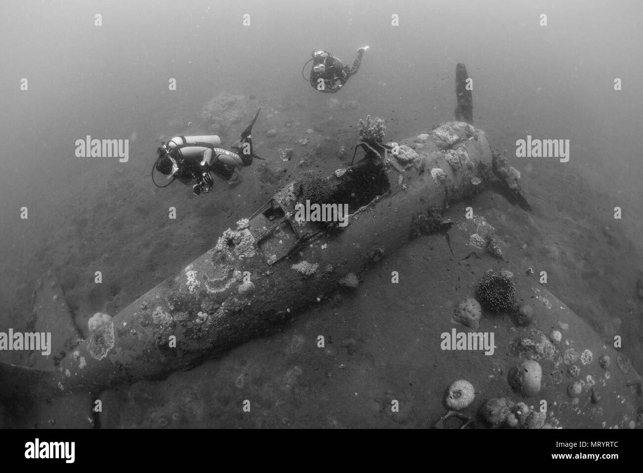 Les plongeurs inspecter une épave d'avion sous-marin nommé le 'zéro' se trouve sur le sable de Kimbe Bay, Papouasie Nouvelle Guinée Banque D'Images
