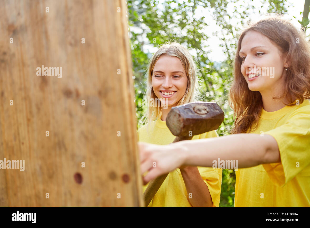 Deux femmes font équipe avec sledgehammer dans un atelier de team building Banque D'Images
