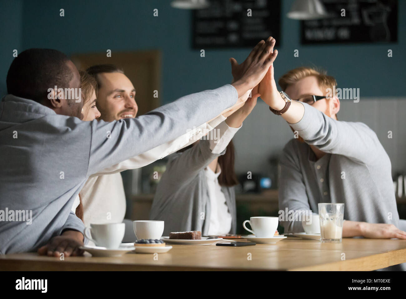 Heureux amis multiraciale cafe haut donnant cinq à répondre à ca Banque D'Images