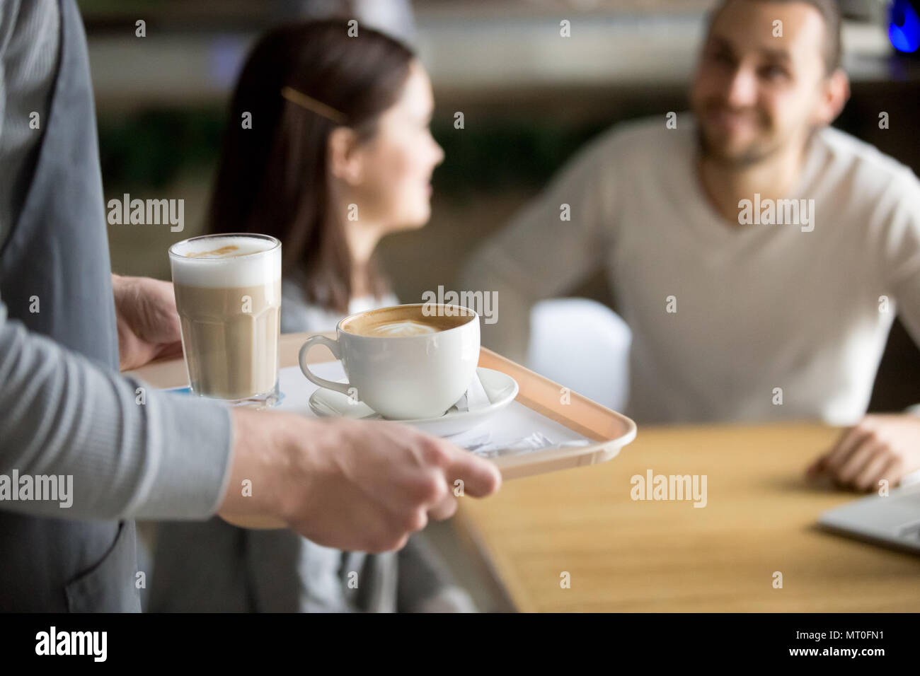 Waitress serving cappuccino et latte de couple dans un café, closeup Banque D'Images