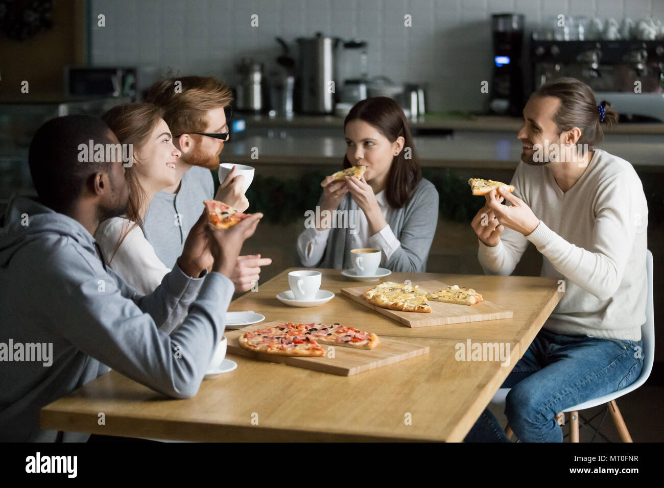 Multiraciale souriante amis parler de boire du café eating pizza Banque D'Images