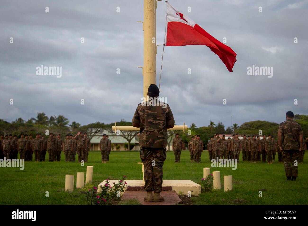 Un membre de Sa Majesté des Tonga dans les Forces canadiennes soulève le tonguien drapeau au cours d'une cérémonie d'ouverture de l'exercice pour TAFAKULA sur l'île de Tongatapu (Tonga, le 17 juillet 2017. TAFAKULA d'exercice est conçu pour renforcer l'armée à militaires relations entre Sa Majesté des Tonga dans l'Armée, l'armée française de Nouvelle Calédonie, New Zealand Defence Force, et les Forces armées des États-Unis. (U.S. Marine Corps photo par MCIPAC le Caméra de combat. Juan C. Bustos) Banque D'Images