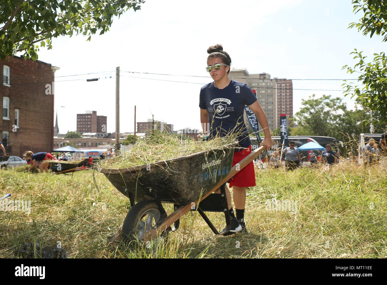 Felicia Perez, Semper Fidelis All-American, efface de brosse par un lot vacant à Baltimore, Maryland, dans le cadre du projet de service communautaire au cours de la séance inaugurale de l'Académie a gagné des batailles, le 15 juillet 2017. L'Académie a gagné des batailles est une partie de la Marine Corps' Semper Fidelis All-American" Programme, qui reconnaît les jeunes hommes et femmes qui excellent dans l'athlétisme, mais ont également montré eux-mêmes d'être des leaders dans leur classe et dans leur ville. Quatre-vingt-dix-sept étudiants-athlètes de l'école secondaire est allé(e) à l'académie, qui a porté sur le développement de leur confiance en soi, la discipline, le travail d'équipe, et au perfectionnement de l'esprit de lutte Banque D'Images