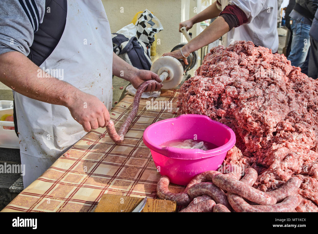 Le Boucher fait des saucisses en plein air de façon traditionnelle. Banque D'Images