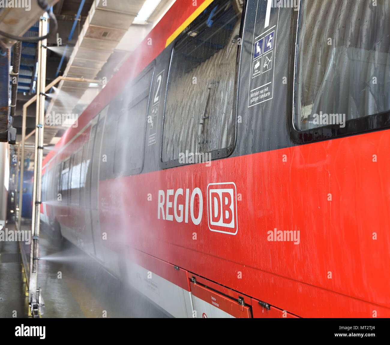 28 mai 2018, Berlin, Allemagne : un train régional de la Deutsche Bahn circulant sur le lavage de voiture de l'atelier DB Regio à Berlin-Lichtenberg. Jusqu'à 12 trains peuvent être nettoyées tous les jours. Dans l'année environ 220 000 mètres de train sont lavés. Photo : Bernd Settnik/dpa-Zentralbild/dpa Banque D'Images