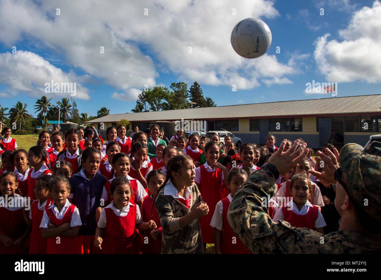 Le Corps des Marines des États-Unis. Phillip Nantas, un carabinier avec 3e bataillon du 4e Régiment de Marines attaché à la Force opérationnelle 17 Koa Moana lance un ballon de soccer à un groupe d'enfants à l'école élémentaire Lapaha comme un cadre de l'exercice, TAFAKULA sur l'île de Tongatapu (Tonga, le 20 juillet 2017. TAFAKULA d'exercice est conçu pour renforcer l'armée à militaires, et les relations communautaires entre Sa Majesté des Tonga dans l'Armée, l'armée française de Nouvelle Calédonie, New Zealand Defence Force, et les Forces armées des États-Unis. (U.S. Marine Corps photo par MCIPAC le Caméra de combat. Juan C. Bustos) Banque D'Images