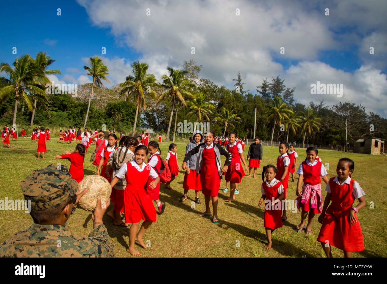 Le Corps des Marines des États-Unis. Austin Bazarivera, une machine gunner avec 3e bataillon du 4e Régiment de Marines attaché à la Force, 17 Koa Moana lance une balle à un groupe d'enfants à l'école élémentaire Lapaha comme un cadre de l'exercice, TAFAKULA sur l'île de Tongatapu (Tonga, le 20 juillet 2017. TAFAKULA d'exercice est conçu pour renforcer l'armée à militaires, et les relations communautaires entre Sa Majesté des Tonga dans l'Armée, l'armée française de Nouvelle Calédonie, New Zealand Defence Force, et les Forces armées des États-Unis. (U.S. Marine Corps photo par MCIPAC le Caméra de combat. Juan C. Bustos) Banque D'Images