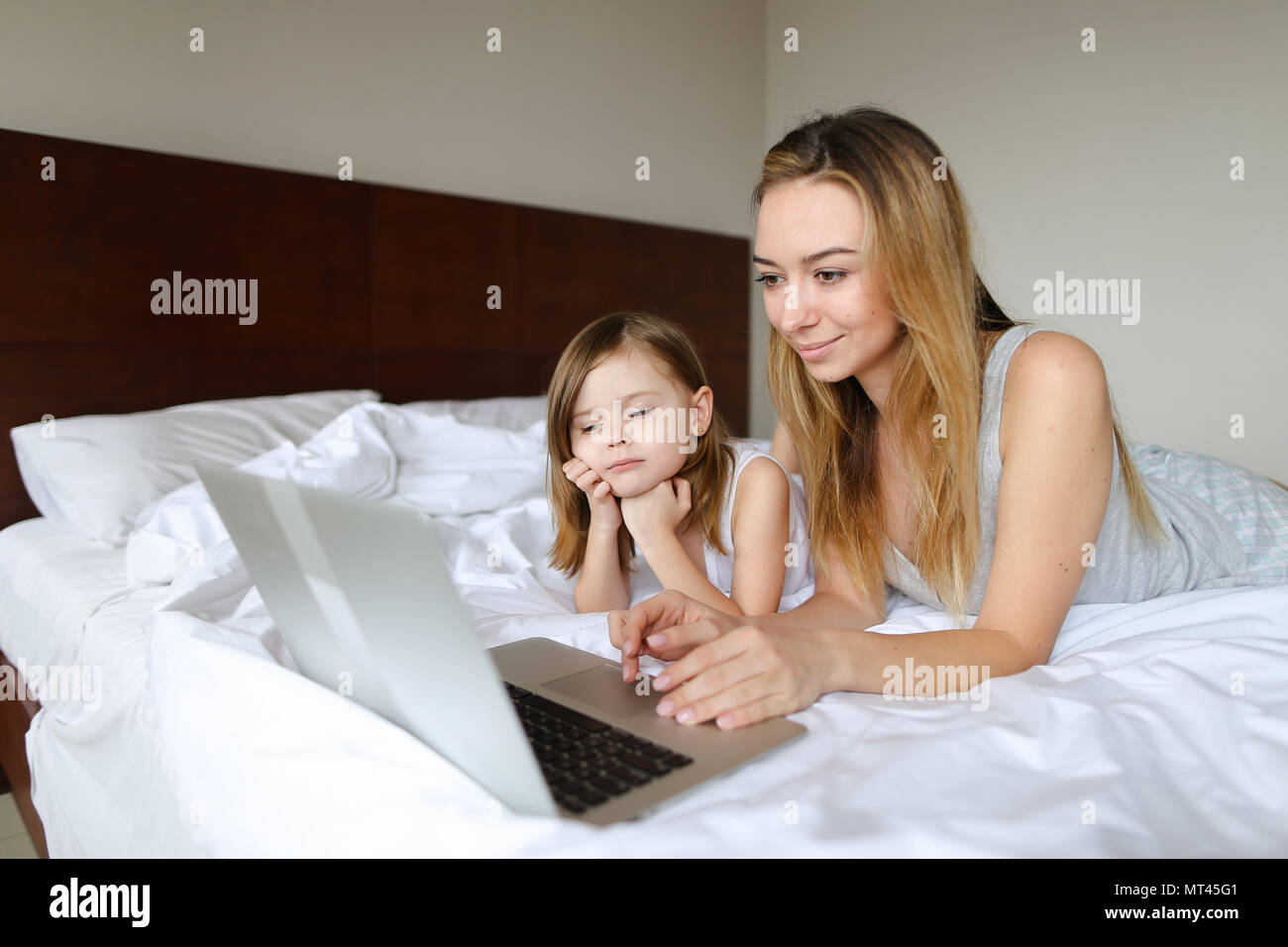 Jeune belle mère au lit avec ma petite fille et à l'aide d'ordinateur  portable Photo Stock - Alamy