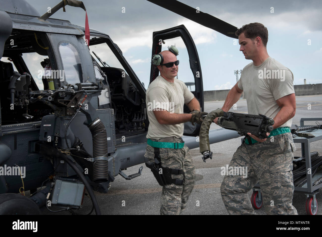 Les cadres supérieurs de l'US Air Force Airman Zachary Hough et le sergent. Ryan Anderson, 33e Unité de maintenance d'hélicoptères section armes armes charger des techniciens, charger un GAU-18 canon de calibre 50 sur un HH-60 Pave Hawk de la 33e Escadron de sauvetage Le 26 juillet 2017, à Kadena Air Base, au Japon. La 33e rouge joue un rôle vital dans le maintien de la paix et de la stabilité dans la région du Pacifique en fournissant de l'avant la projection de puissance et de rechercher, de sauvetage et de récupération les capacités de mission. (U.S. Photo de l'Armée de l'air par les cadres supérieurs d'un membre de la John Linzmeier) Banque D'Images