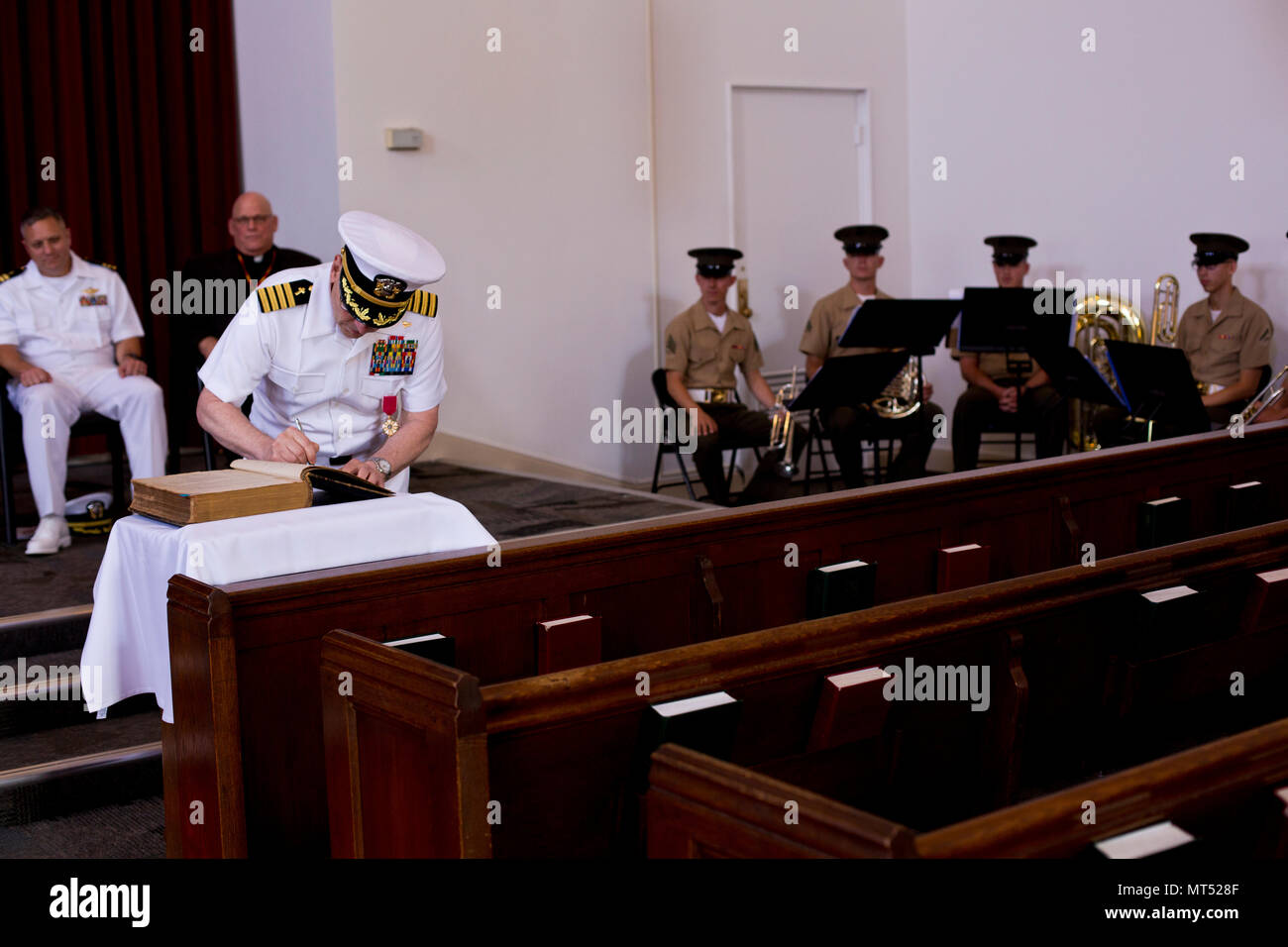 Le Capitaine de vaisseau américain Michael A. Mikstay, aumônier du dépôt avec Marine Corps Recruter Depot (MCRD) San Diego, signe un livre au cours d'une cérémonie à la retraite MCRD San Diego, Californie, le 12 mai 2017. La cérémonie de la retraite a eu lieu en l'honneur du Capitaine Michael A. L'Mikstay service honorable dans la Marine. (U.S. Marine Corps photo par Lance Cpl. Erick J. ClarosVillalta) Banque D'Images