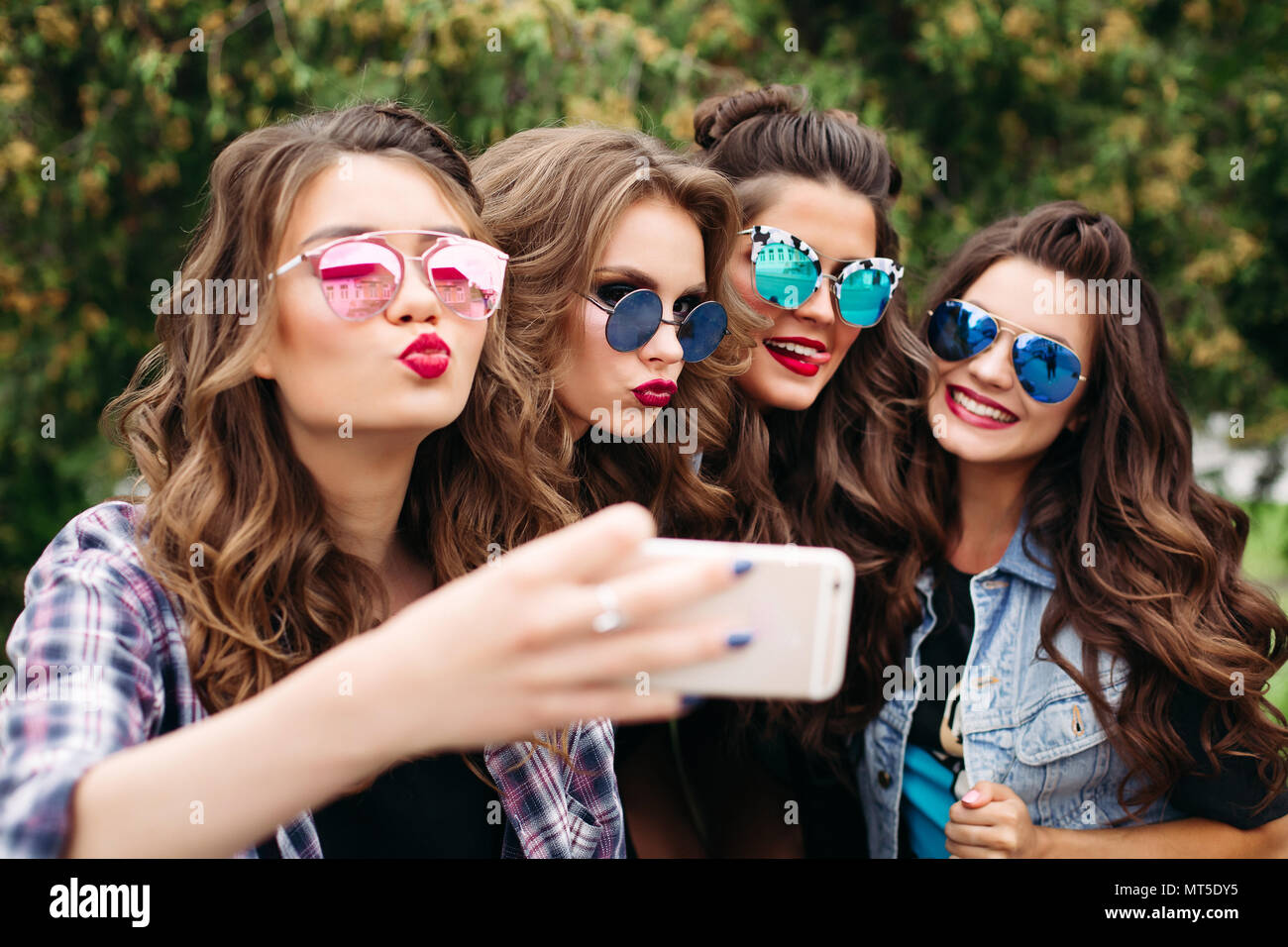 Mesdames mode avec hairstyle en tenant l'extérieur selfies. Banque D'Images