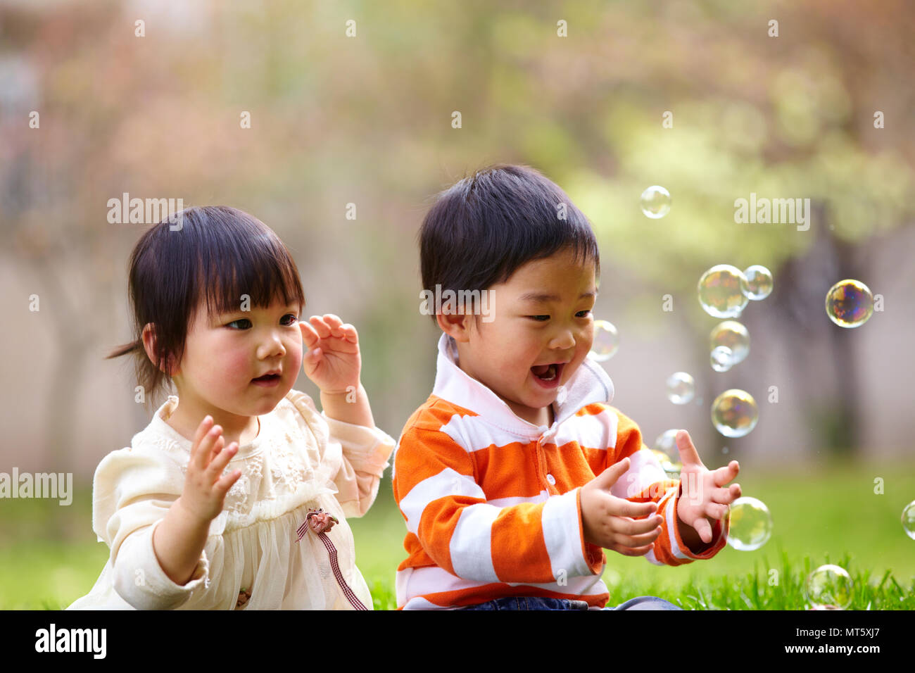 Deux professionnels peu d'enfants d'Asie en plein air le parc ensoleillé Banque D'Images