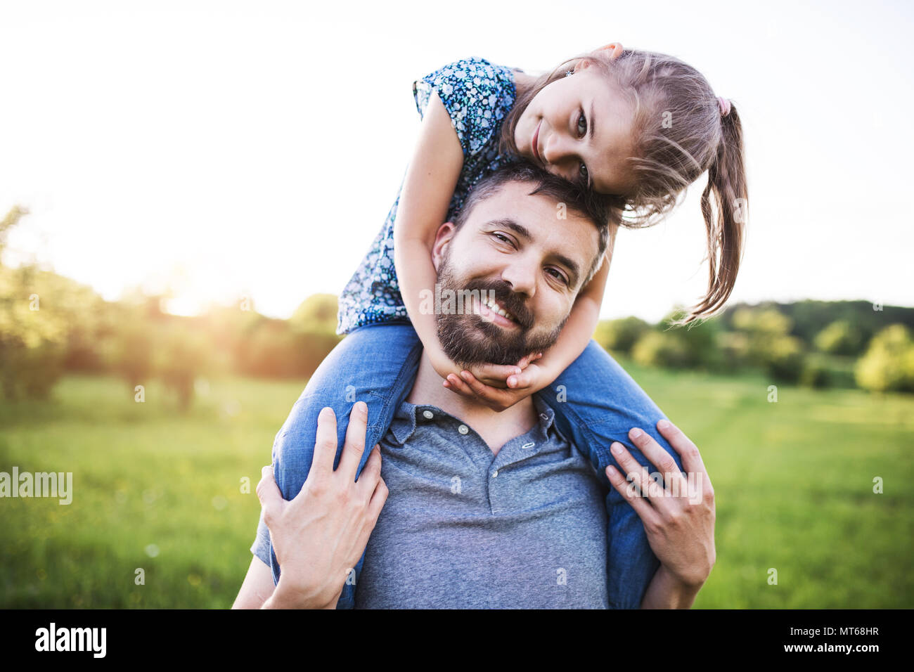 Petite fille un père donnant piggyback ride au printemps la nature. Banque D'Images