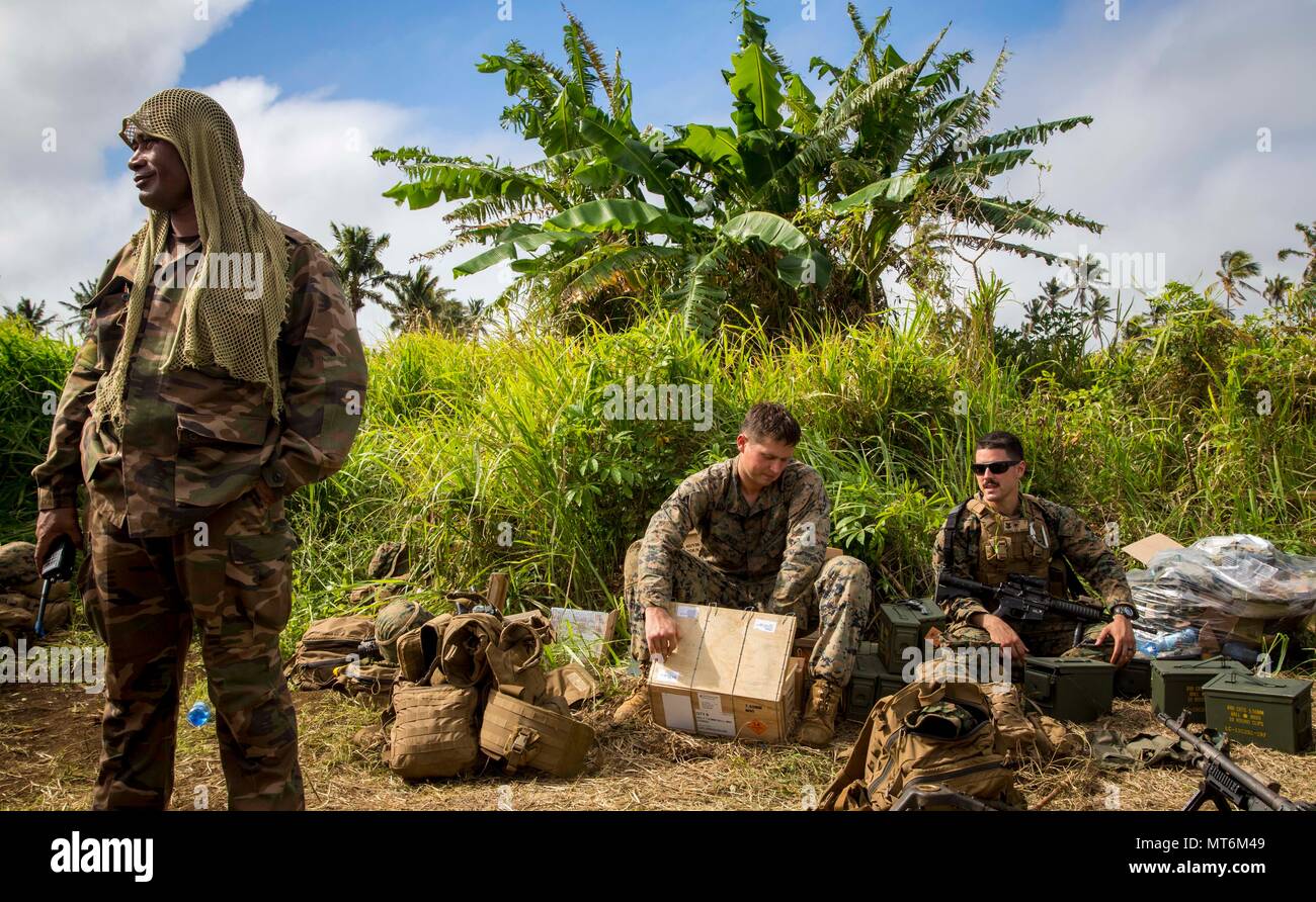 Le sergent du Corps des Marines des États-Unis. Ian Pass, centre, un mitrailleur avec 3e bataillon du 4ème Marines, ouvre une caisse de munitions au cours de l'effort, TAFAKULA sur l'île de Tongatapu (Tonga, le 21 juillet 2017. TAFAKULA d'exercice est conçu pour renforcer l'armée à militaires, et les relations communautaires entre Sa Majesté des Tonga dans l'Armée, l'armée française de Nouvelle Calédonie, New Zealand Defence Force, et les Forces armées des États-Unis. (U.S. Marine Corps photo par MCIPAC le Caméra de combat. Juan C. Bustos) Banque D'Images
