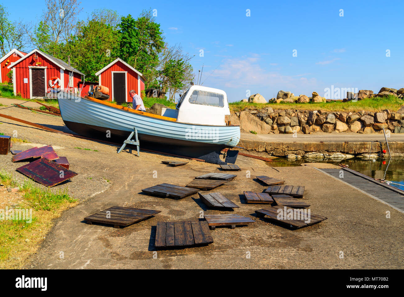 Kattvik, Bastad, Suède - Mai 16, 2018 : Documentaire de voyage de la vie quotidienne et le lieu. Personne travaillant dans son petit bateau de pêche en bois dans le village Banque D'Images