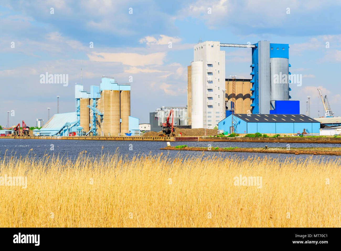 Halmstad, Suède - Mai 16, 2018 : Documentaire de voyage de la vie quotidienne et le lieu. Paysage de l'industrie portuaire avec les silos et les grues sur un après-midi ensoleillé. Banque D'Images