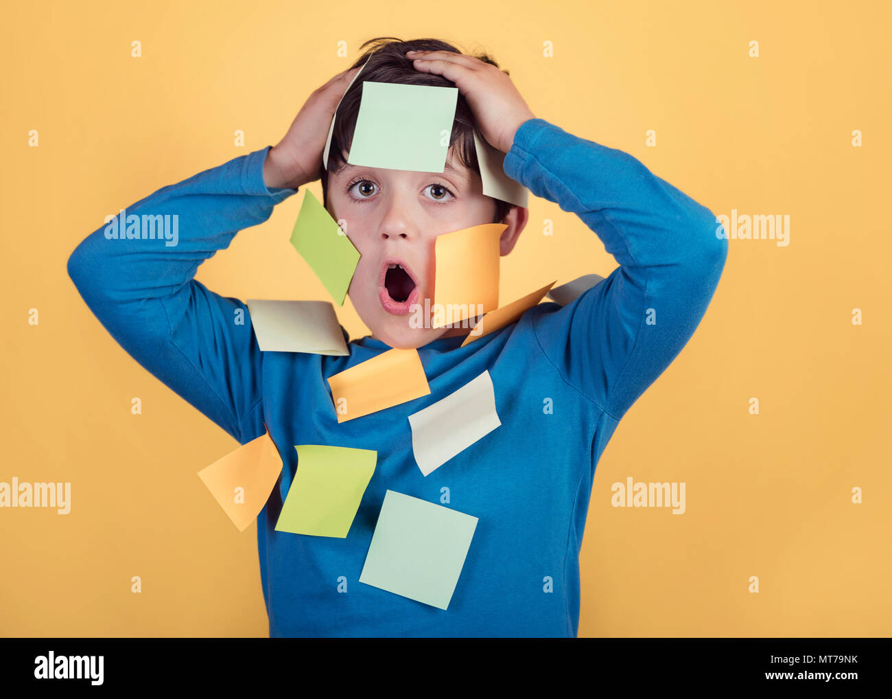 Portrait d'enfant avec note papers bloqué sur corps sur fond jaune Banque D'Images