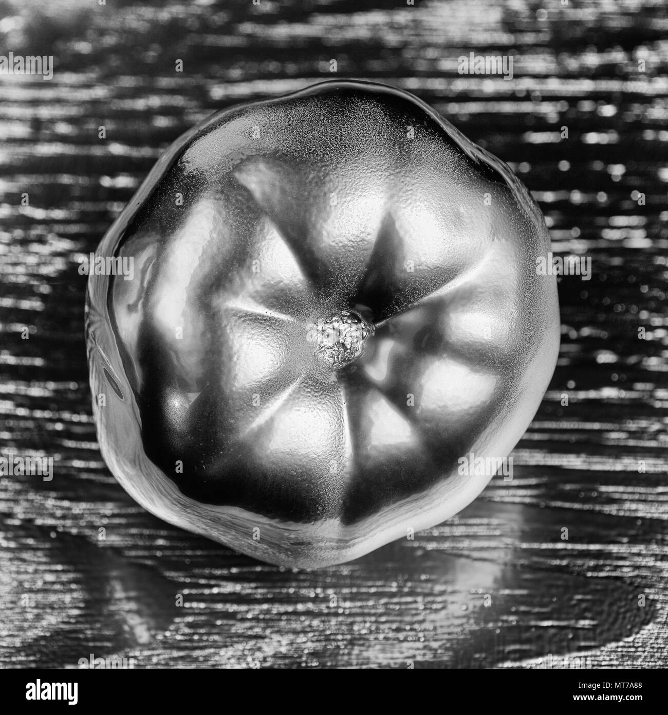 L'argent métallique concept tomate sur fond de bois d'argent. un minimum d'aliments et de légumes idée concept. Une idée créative pour produire un travail au sein d'une publicité marketing communications ou artwork design. Banque D'Images