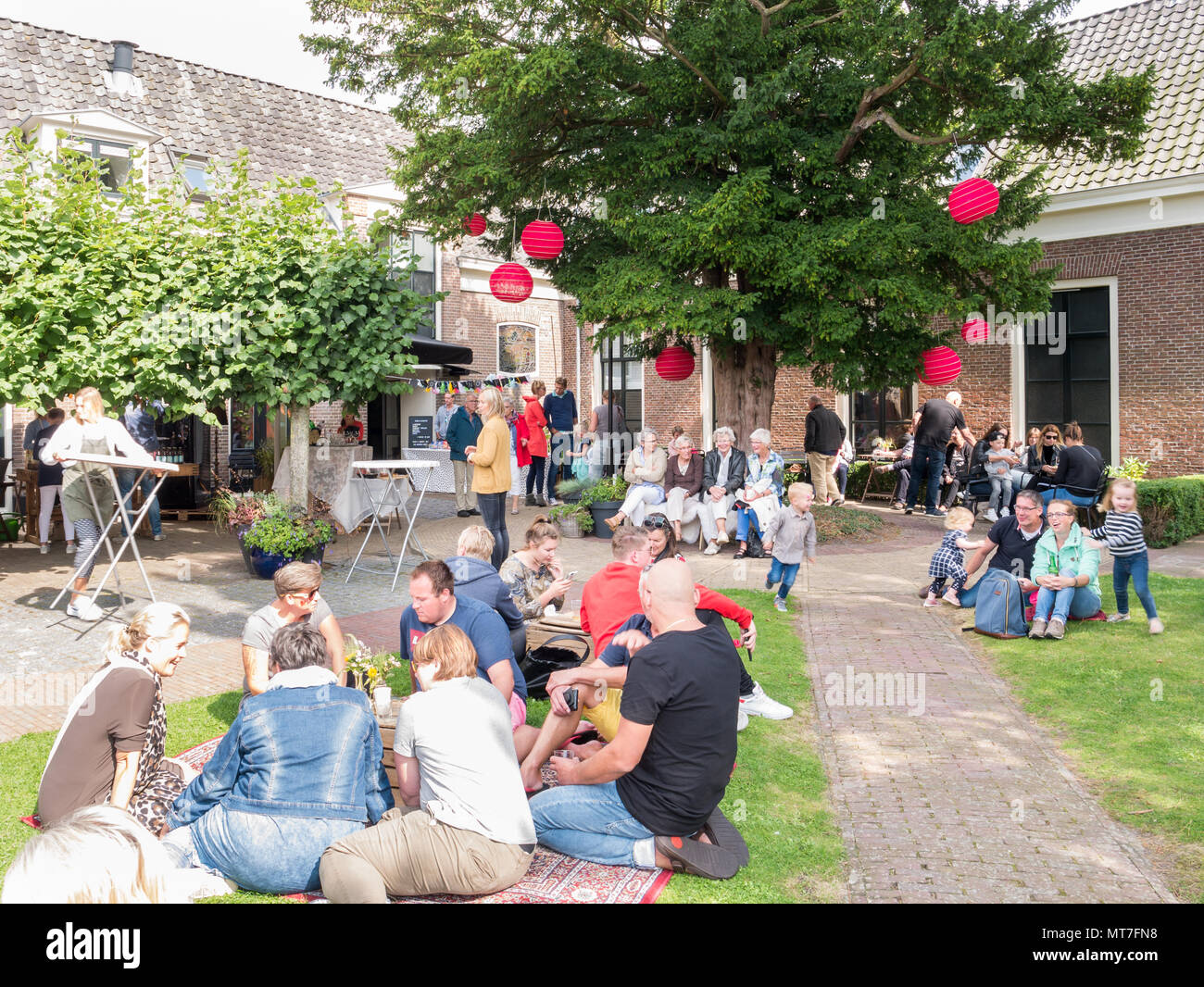 Les personnes bénéficiant des collations et des boissons sur street food festival au jardin de l'ancien orphelinat en ville historique de Bolsward, Frise, Pays-Bas Banque D'Images