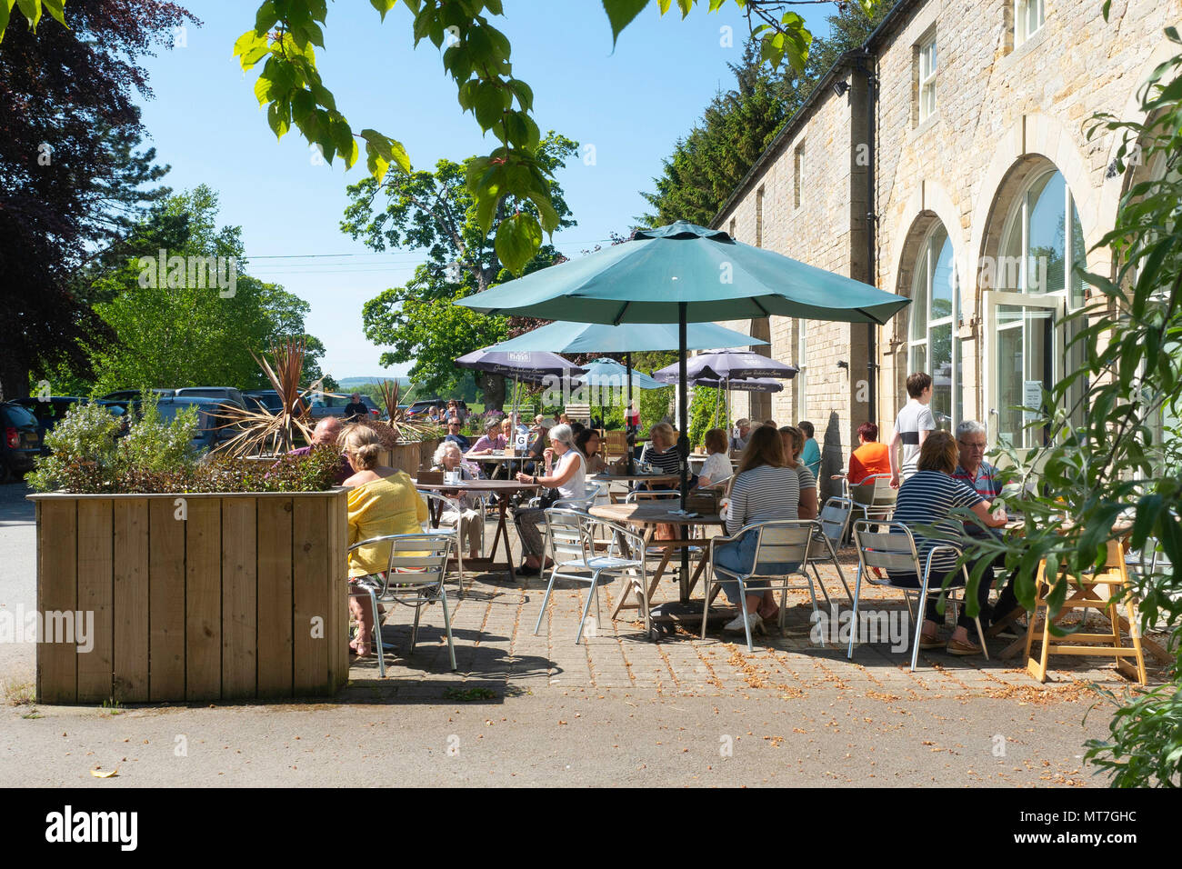 Eggleston Hall café et salon de thé avec les clients profitant soleil du printemps sur les tables à l'extérieur à Eggleston Durham England UK Banque D'Images