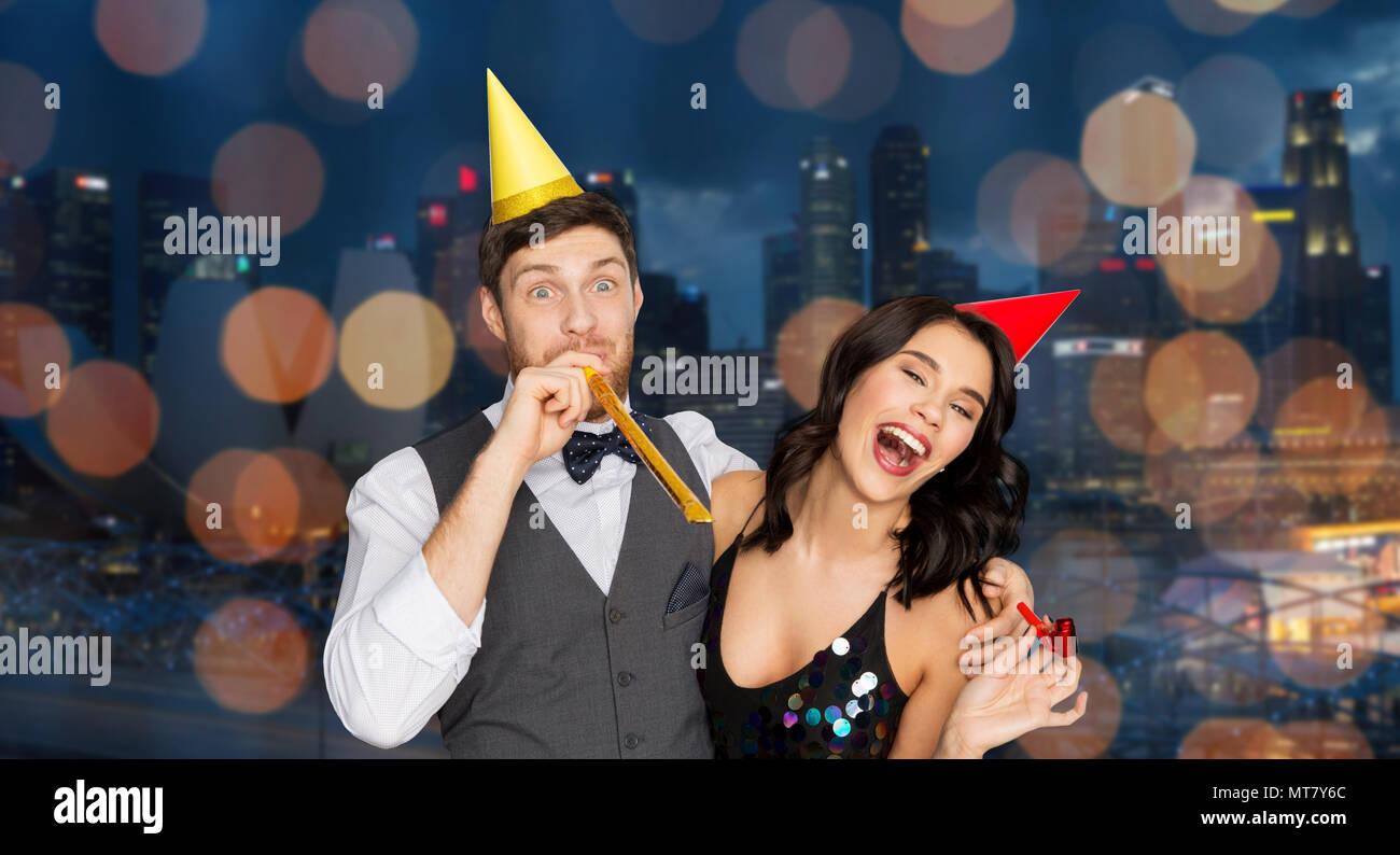 Couple heureux avec party blowers s'amusant Banque D'Images