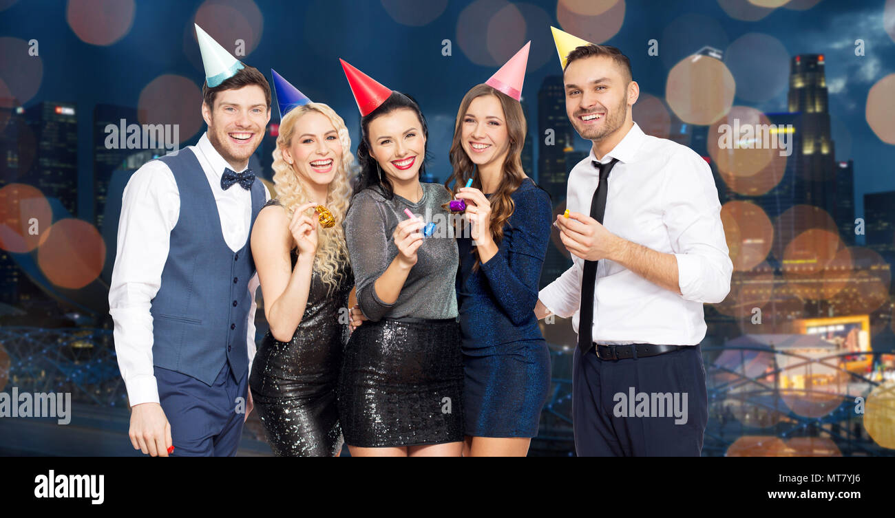 Happy friends avec party blowers s'amusant Banque D'Images