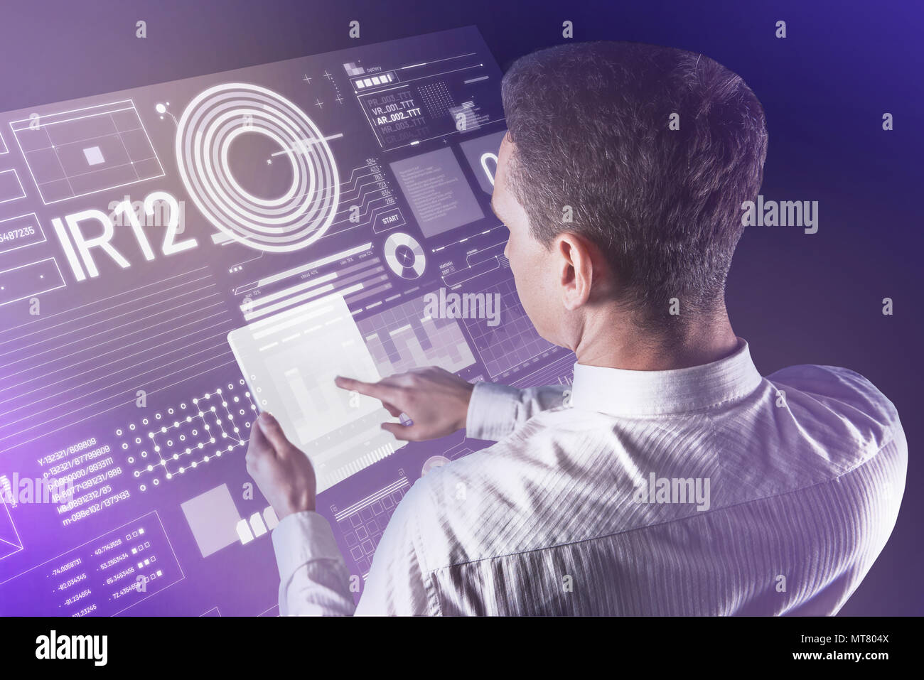 Calme Jeune homme tenant une tablette futuriste et vérification de l'information Banque D'Images