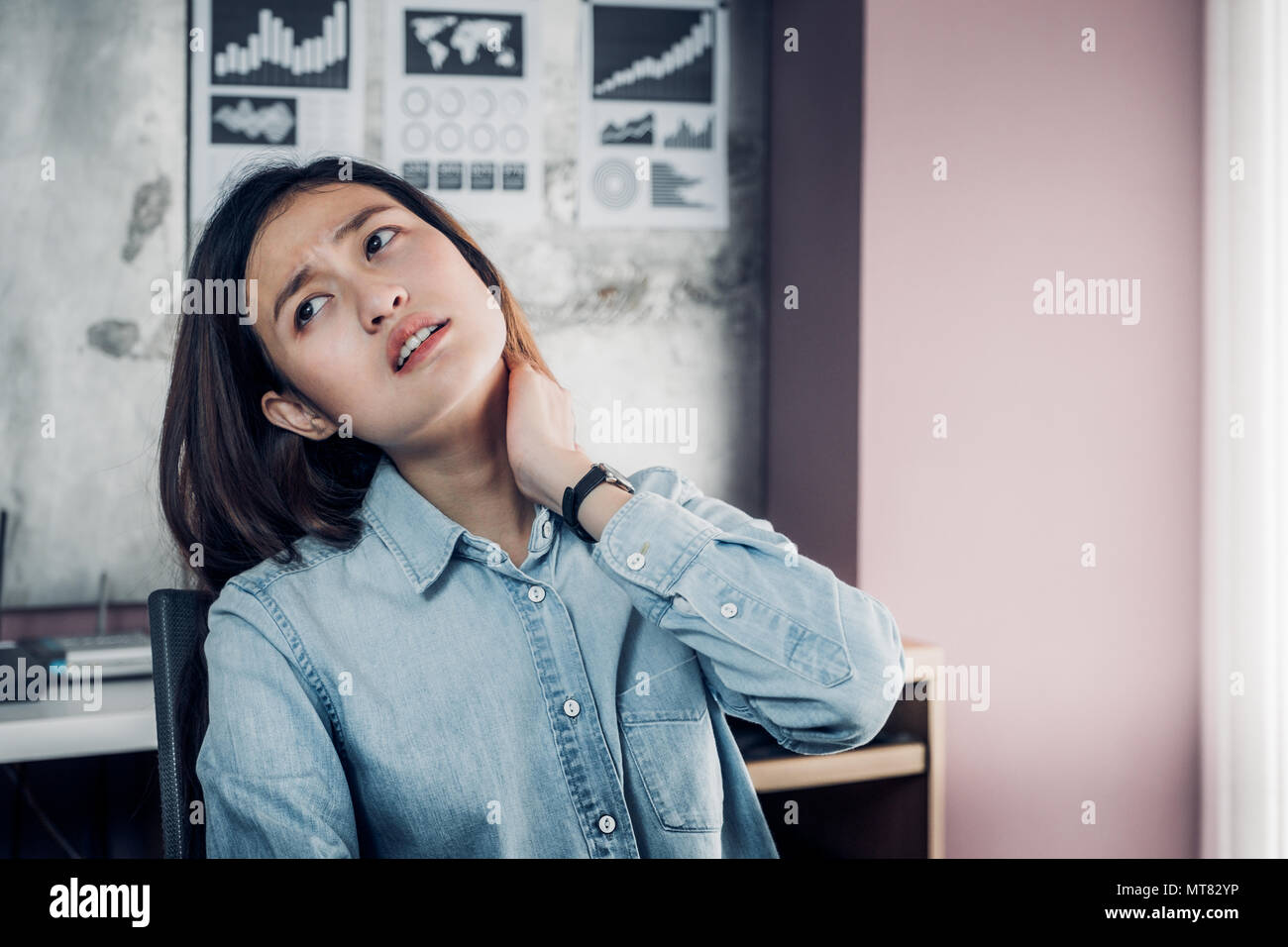 Syndrome de bureau,designer asiatique cou ache lors du travail, utiliser la manette d'attraper son cou douleur de travail dur longtemps en face de votre ordinateur lors de l'établissement Banque D'Images