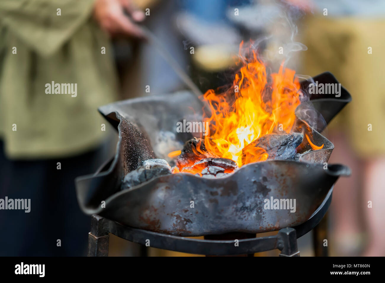 Un feu brûlant et les flammes en grille métallique, main de l'homme Banque D'Images