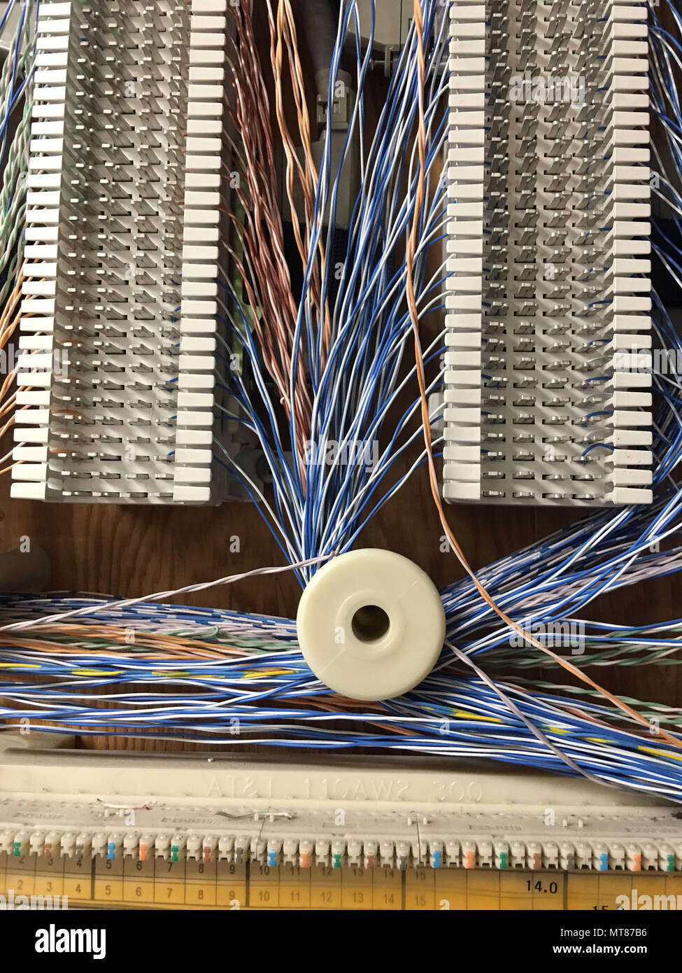 Multi couleur petit diamètre câbles courent autour de bobines montées aux conseils dans la chambre Téléphone Banque D'Images