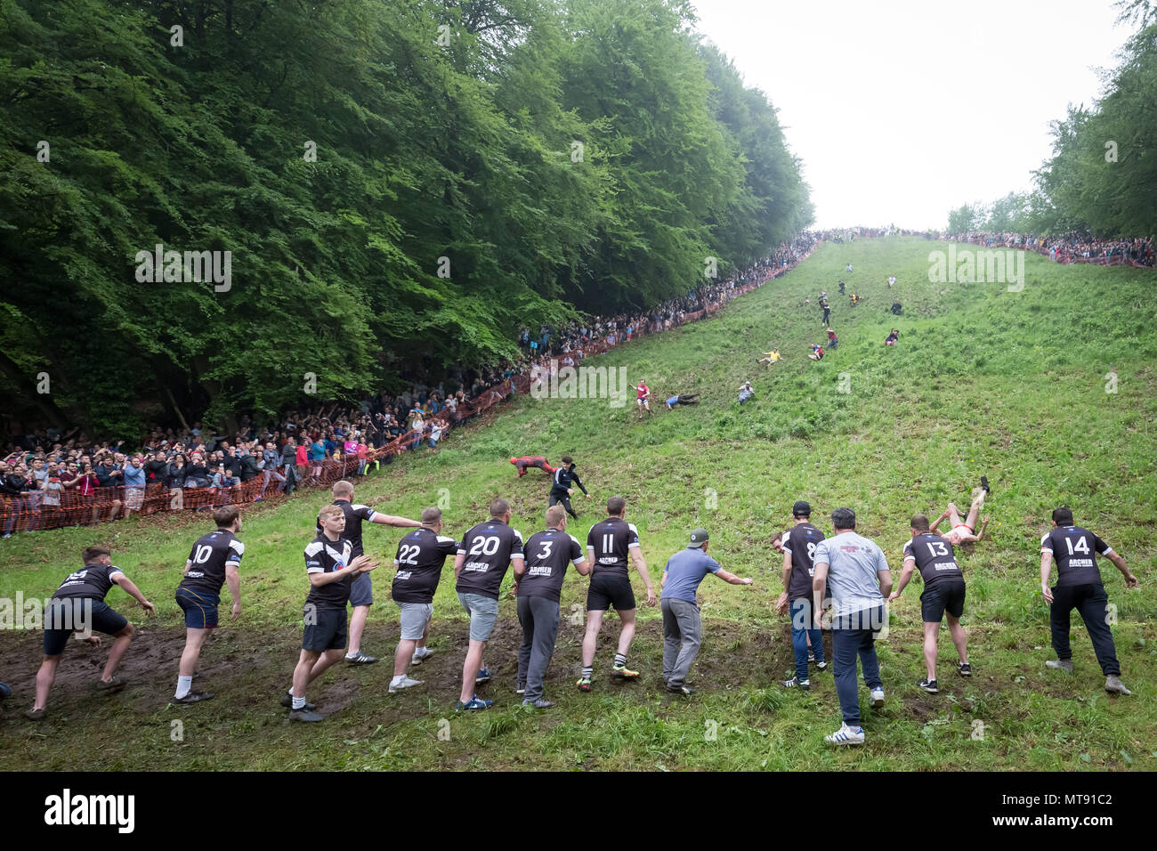 Gloucester, Royaume-Uni. 28 mai 2018. Rouleau de fromage annuel sur Coopers Hill. Datant de 1800, l'assemblée annuelle et Cheese-Rolling service implique la course concurrents audacieux qui poursuivait un 9lb (4,1 kg) tour de fromage Double Gloucester 200 mètres en bas de la colline de gradient 1:2. Le fromage a droit à une deuxième longueur d'avance et peut atteindre des vitesses allant jusqu'à 70mph. Il y a habituellement un certain nombre de blessures chaque année. Crédit : Guy Josse/Alamy Live News Banque D'Images