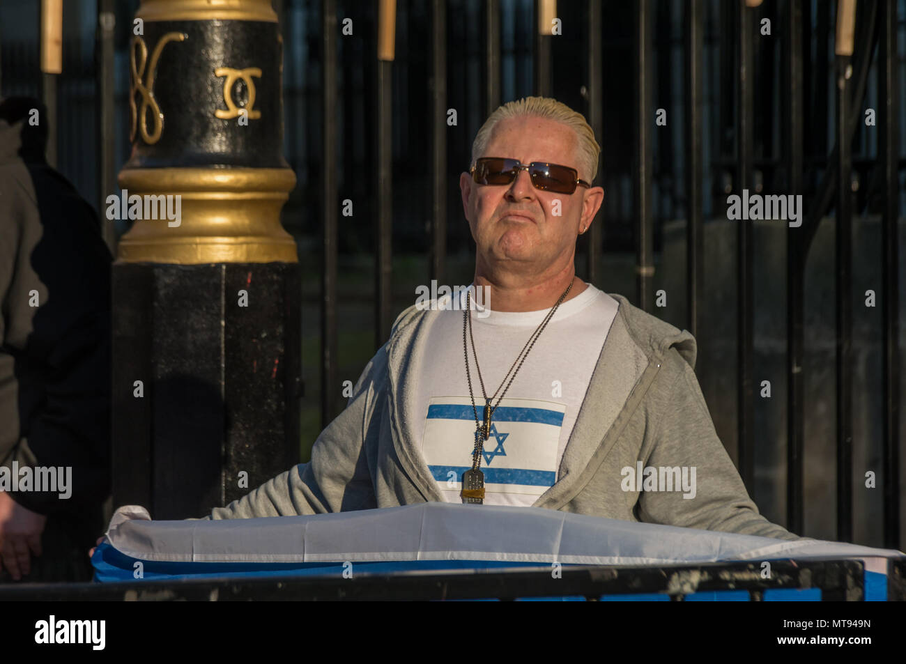 15 mai 2018 - Hier, les manifestants qui ont entraîné 58 décès et plus de 2700 blessés graves, avec une poignée de sionistes vague des drapeaux israéliens et soutenir les actions illégales des forces israéliennes. L'un avait une étoile de David tatoué sur son visage et un t-shirt à nier l'existence de la Palestine, et l'autre agité un drapeau de la Force de défense d'Israël. Les policiers ont encerclé par une double couche d'obstacles et se tint le long de l'extérieur d'eux, mais les autres manifestants ont été tout simplement les ignorer. Il n'était pas clair combien de cinq étaient juifs, mais il y avait beaucoup, beaucoup plus de Juifs à quelques mètres protestent contre un Banque D'Images