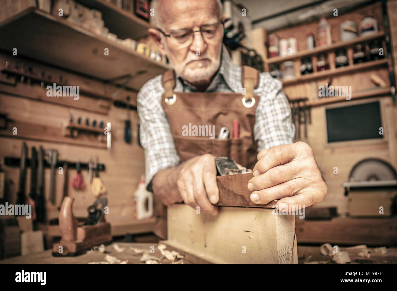 Vieux carpenter utilise une raboteuse Banque D'Images