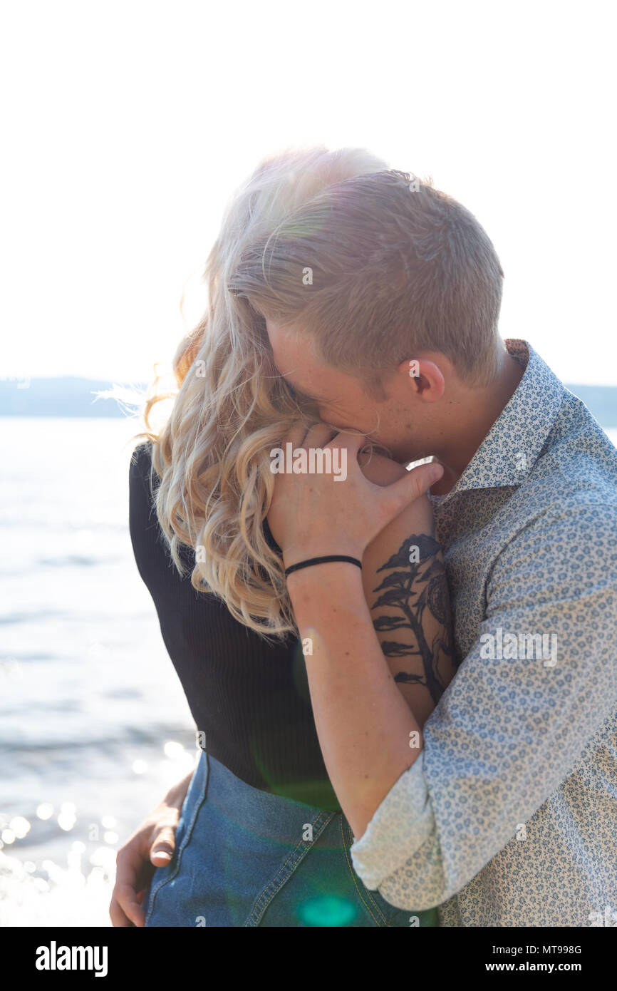 Beau couple romantique à embrasser sur la plage au soleil. Flirt d'été à l'extérieur. Banque D'Images