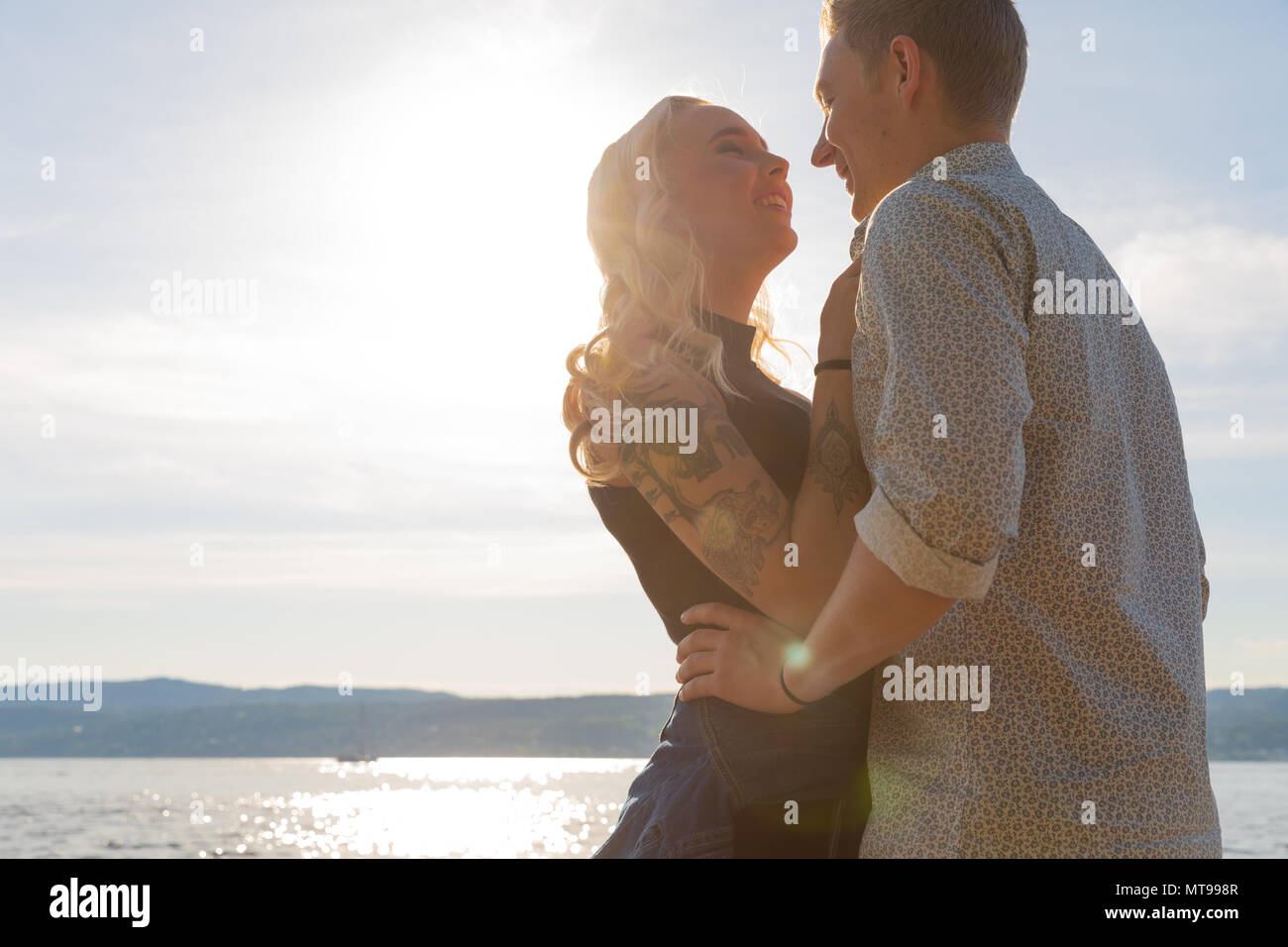 Beau couple romantique à embrasser sur la plage au soleil. Flirt d'été à l'extérieur. Banque D'Images
