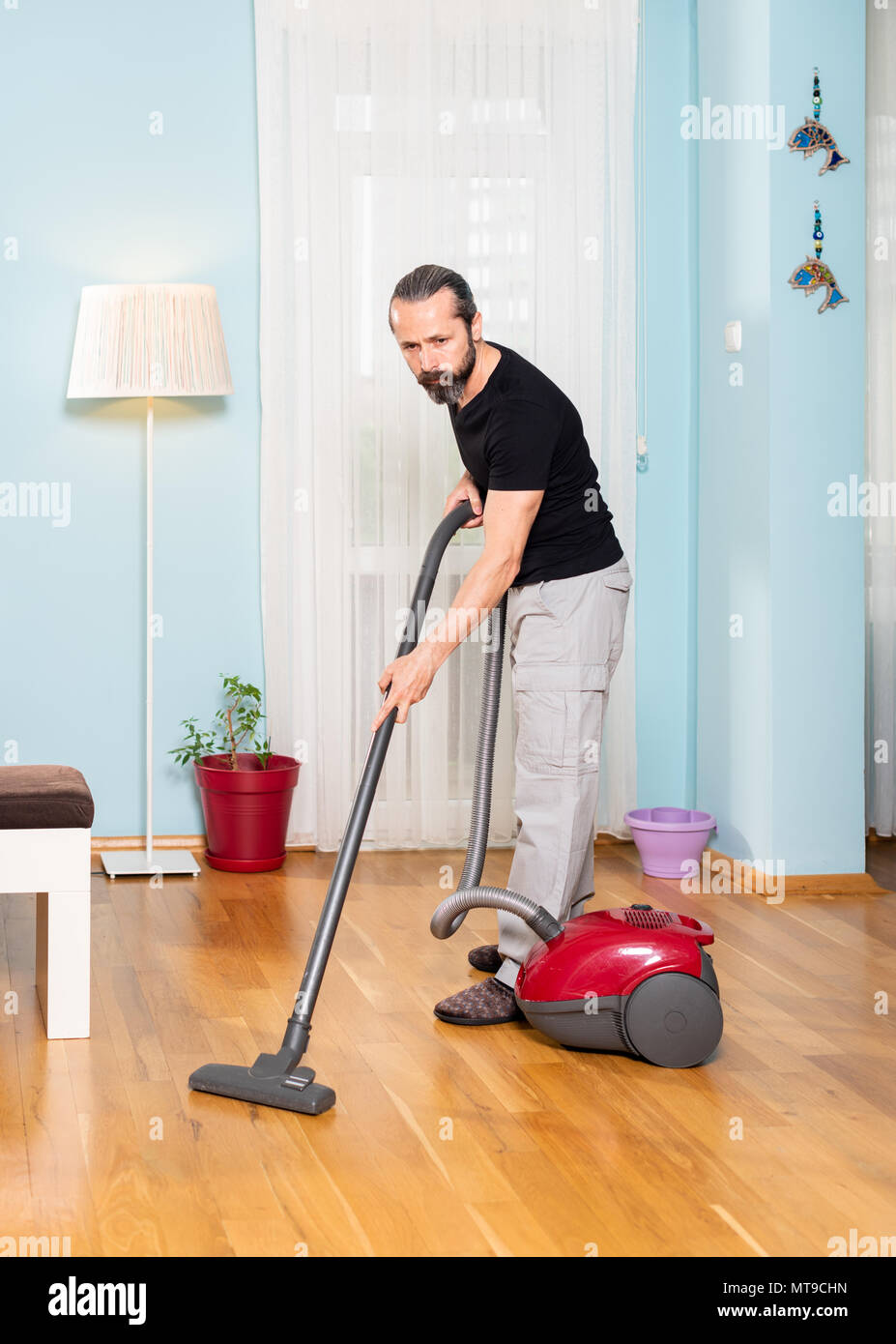 Une maison en bois, balayant l'homme travailler avec machine à balai Banque D'Images