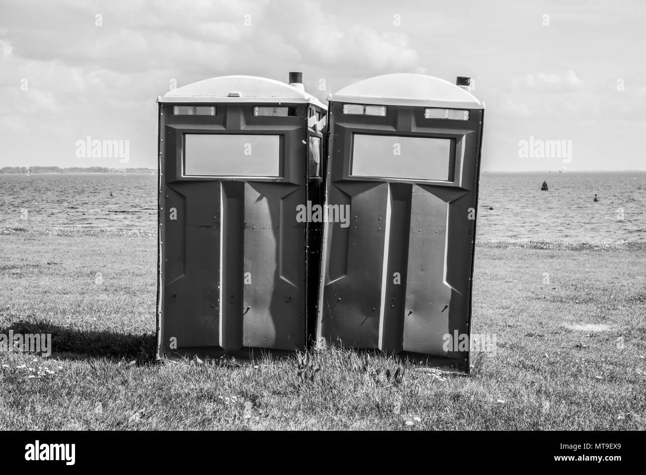 Toilettes mobiles sur une plage. Image en noir et blanc Banque D'Images