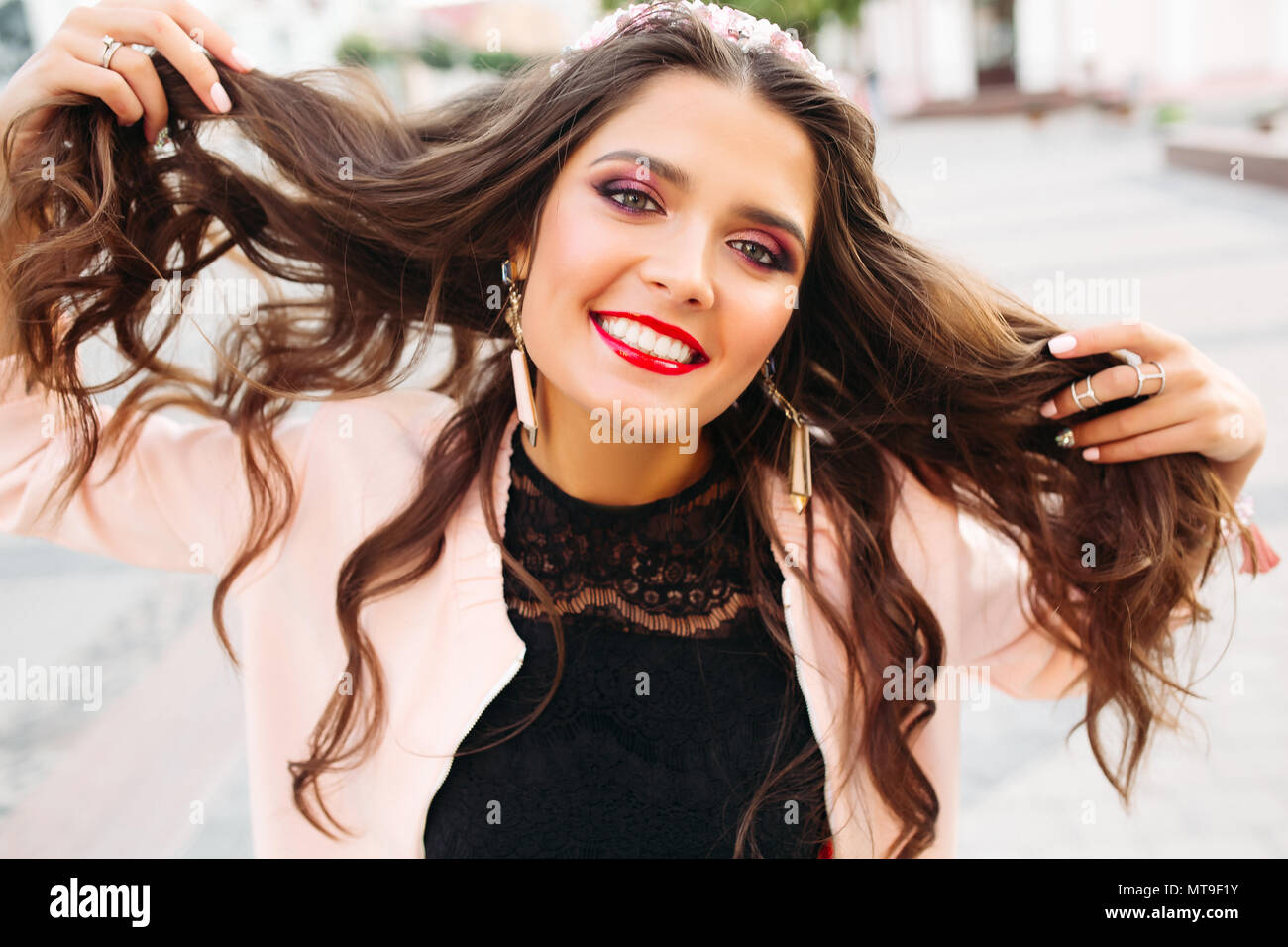 Belle fille brune avec des composent maintenant ses cheveux et smiling at camera. Banque D'Images
