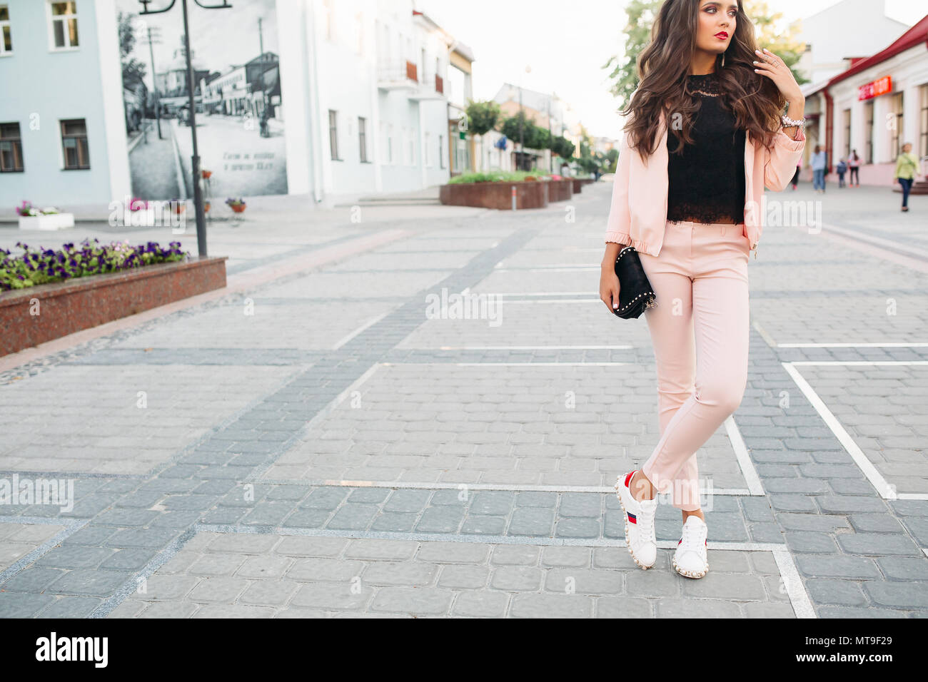Petite fille en rose élégant costume chic sport, dentelle top et sneakers  posant dans la rue avec sac bandoulière petite dans la main Photo Stock -  Alamy