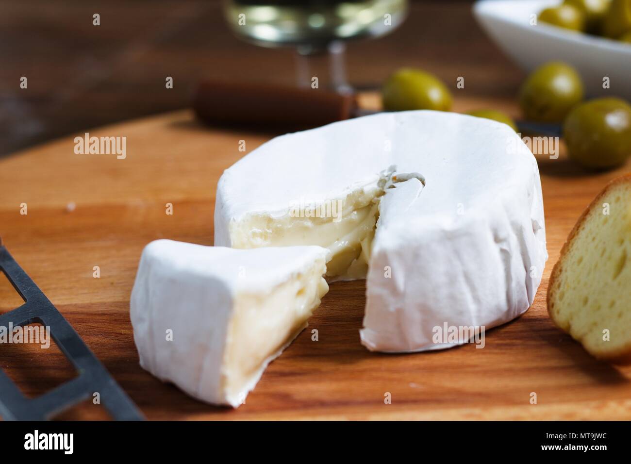 Gros plan de la roue de coupe de fromage à croûte tendre blanc (camembert ou brie) avec petit morceau coupé pour montrer la texture magnifique Banque D'Images
