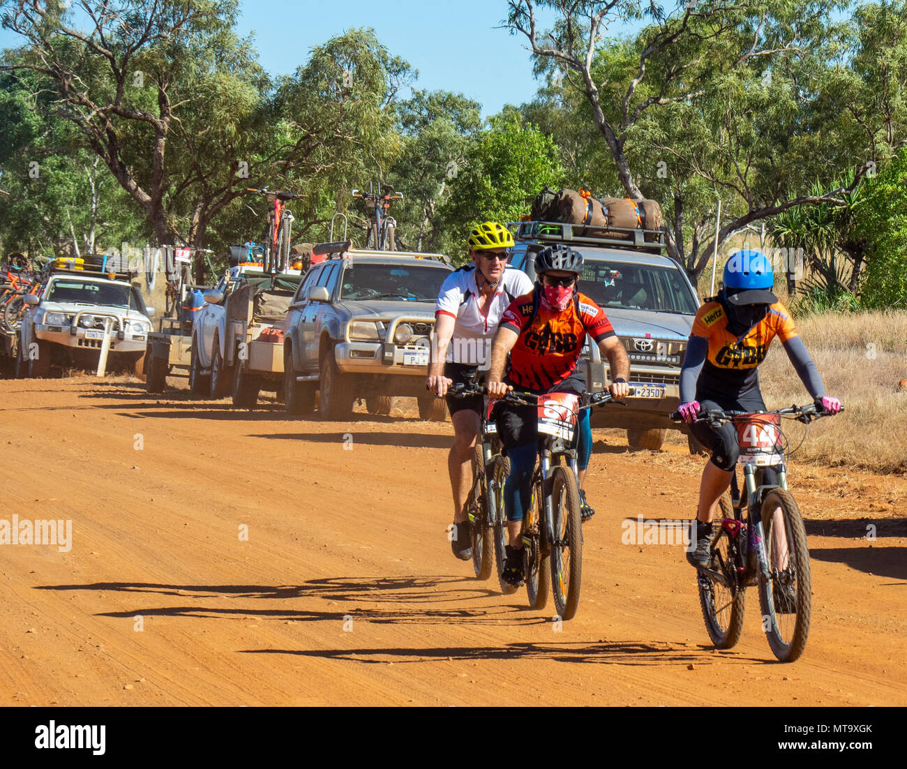 Les cyclistes en vtt équitation passé un convoi de véhicules de soutien sur la Gibb River Road de saleté sur le Défi 2018 Gibb, Kimberley WA, Australie. Banque D'Images
