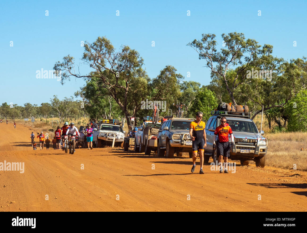 Les cyclistes en vtt équitation passé un convoi de véhicules de soutien sur la Gibb River Road de saleté sur le Défi 2018 Gibb, Kimberley WA, Australie. Banque D'Images