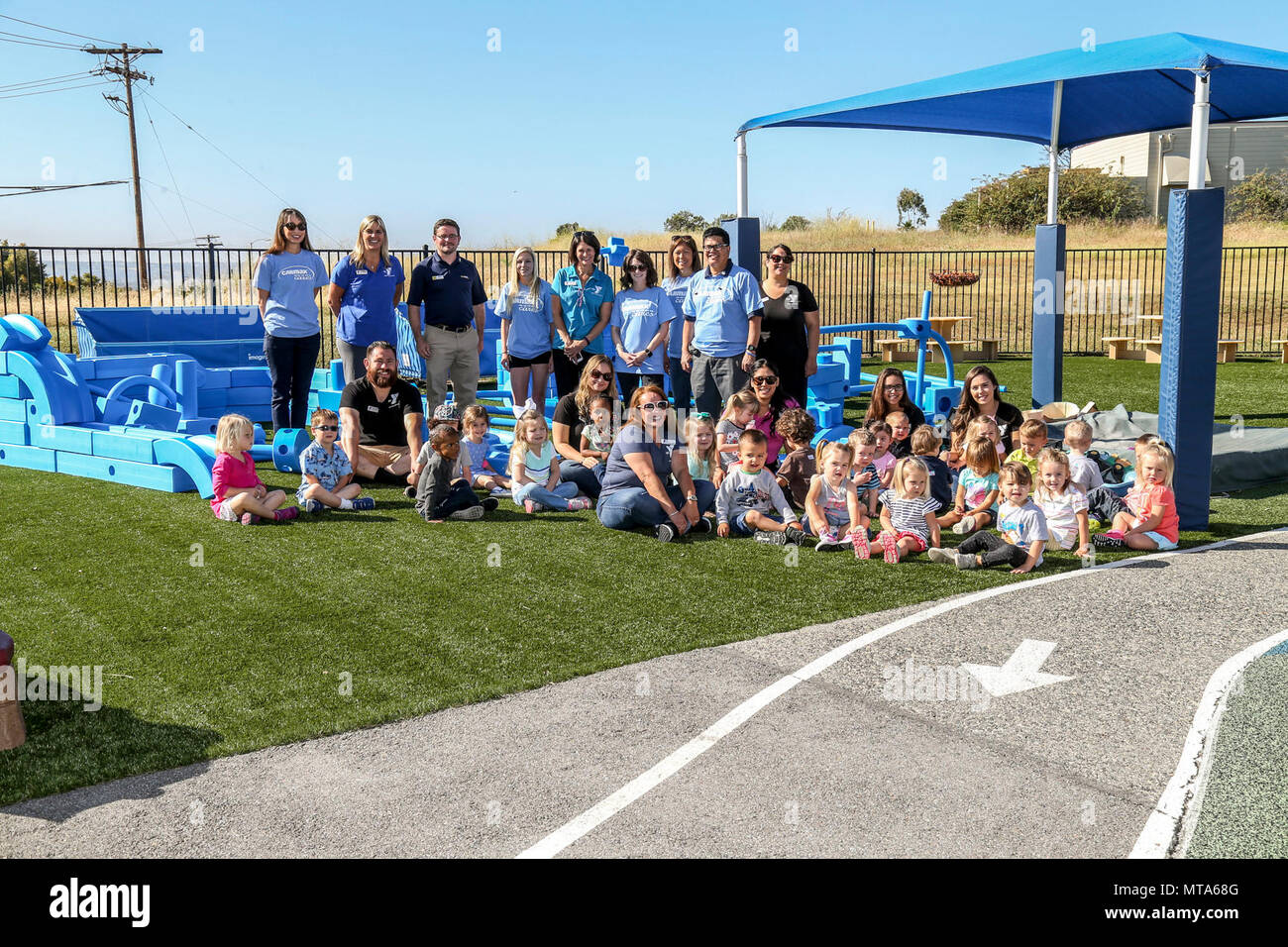 Plus agile d'Escondido, les pêcheurs, les travailleurs d'un centre pour les enfants et les enfants posent pour une photo de groupe durant une semaine de 'Jouer' sur l'événement Camp Pendleton, en Californie, le 20 avril 2017. L'Armed Services Young Men's Christian Association, Fisher Children's Centre, a reçu une subvention de la jouer Kaboom plus agile Foundation pour le mois de l'enfant militaire où une "aire d'imagination' a été révélé. Banque D'Images