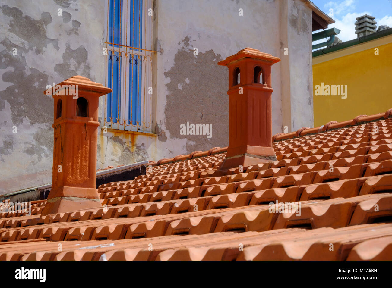 Belles couleurs orange de tuiles en terre cuite et les cheminées d'un toit à Portovenere Italie Banque D'Images