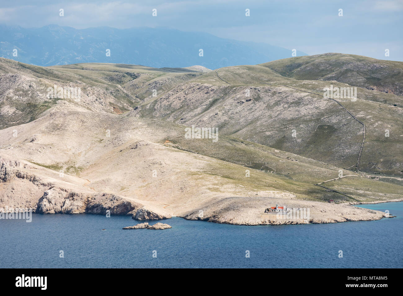 Vieux phare en pierre dans un paysage désertique, peuplée de l'île de Prvic, situé de l'autre côté de Baska, Krk, Croatie Banque D'Images