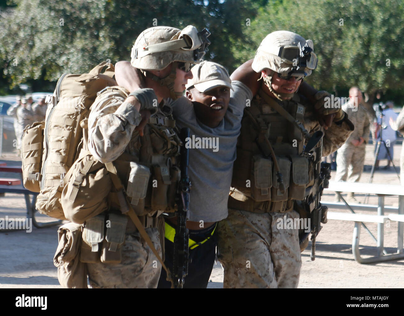 Les Marines américains avec 2e Bataillon, 6e Régiment de Marines, 2e Division de marines aider un acteur blessé au personnel médical lors d'un assaut appuyer trois tactiques (AST-3) dans le cadre de l'exercice des armes et tactiques - Instructeur (WTI) 2-17 au Parc Kiwanis à Yuma (Arizona), le 21 avril 2017. AST-3 est un exercice axé sur la conduite d'opération d'évacuation de noncombattant (Néo) dans un environnement urbain tout en offrant simultanément l'aide humanitaire étrangère (FHA) à la simulation de nation hôte. Le WTI est un événement de formation de sept semaines, organisé par Marine Aviation armes et tactiques d'un escadron (MAWTS-1) l'ACRD Banque D'Images