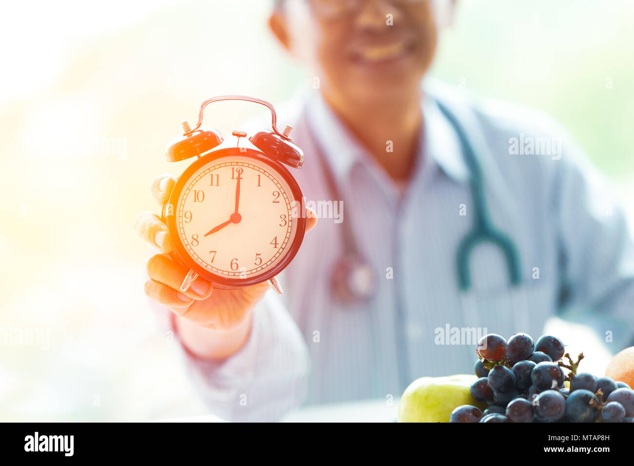 Le temps d'alimentation médecin avec horloge et des fruits sains bien rappeler à concept. Banque D'Images